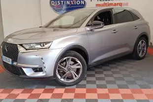 DS7 Crossback gris clair en 3/4 avant droit, avec calandre distinctive et jantes alliage modernes.