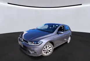 Volkswagen Polo gris 3/4 avant droit, avec projecteurs LED et jantes alliage 16 pouces visibles.