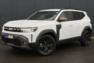 Vue 3/4 avant droite du Dacia Duster blanc Glacier avec coques de rétroviseurs brun cuivré et jantes noires.