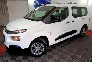 Citroën Berlingo blanc en 3/4 avant droit, avec protections latérales noires et jantes alliage visibles.