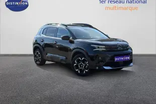 Vue 3/4 avant du Citroën C5 Aircross noir Perla Nera avec jantes alu et barres de toit visibles sur fond neutre.