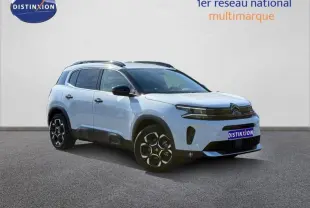 Vue 3/4 avant droite du Citroën C5 Aircross blanc Okénite avec jantes distinctives et toit noir contrasté.