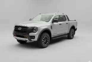Ford Ranger Wildtrak gris en 3/4 avant droit, avec barres de toit et jantes alliage noires.
