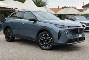 Peugeot 3008 Hybrid bleu Ingaro en 3/4 avant droit, avec calandre distinctive et jantes noires bicolores.