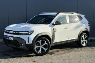 Vue 3/4 avant droit du Dacia Duster blanc glacier avec jantes alliage 18 pouces et barres de toit noires.