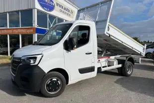 Renault Master blanc 2024 vue 3/4 avant droit avec benne basculante relevée sur parking extérieur.