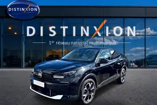 Citroën C4 X noire vue 3/4 avant droit, avec jantes alu et calandre distinctive devant showroom Distinxion.