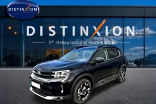 Citroën C5 Aircross noir vue 3/4 avant droit, avec jantes alu distinctives et barres de toit visibles.
