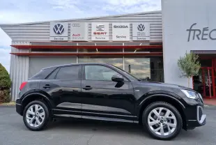 Audi Q2 35 TFSI noir mito metal en vue profil côté gauche, jantes alliage et calandre distinctive visibles.