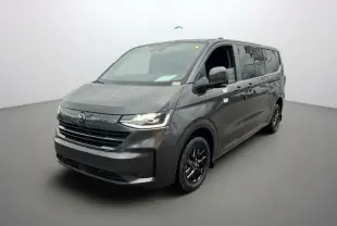 Vue 3/4 avant droite d’un Volkswagen Transporter TDI 170 DSG ProCab L2 gris graphite avec jantes alu noires et feux LED allumés.