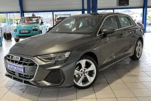 Audi A3 Sportback gris en 3/4 avant droit, avec jantes alliage 5 branches et toit ouvrant panoramique visible en showroom.