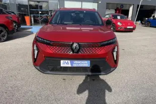 Vue de face du Renault Scénic E-Tech électrique rouge flamme 2024, avec calandre à motif hexagonal et feux LED verticaux.