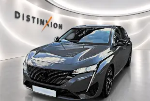 Peugeot 308 gris selenium vue 3/4 avant droit avec calandre noire et feux LED verticaux allumés.