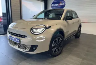 Vue 3/4 avant droit d'une FIAT 600 beige métallisé avec jantes alliage noires et détails chromés showroom.