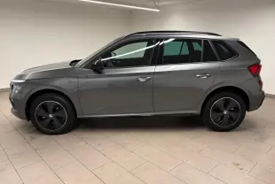 Vue de profil côté gauche d’un Skoda Kamiq 1.5 TSI Monte Carlo gris graphite avec jantes noires distinctives.