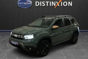 Dacia Duster 2024 kaki lichen en 3/4 avant droit, avec jantes noires et coques de rétroviseurs bronze.
