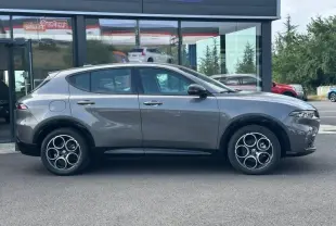 Vue de profil côté gauche d'une Alfa Romeo Tonale 1.5 Hybrid gris Vesuvio métallisé avec jantes alu distinctives.