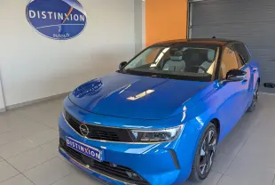 Vue 3/4 avant d'une Opel Astra 2022 bleu avec toit noir et jantes alliage bicolores en showroom.