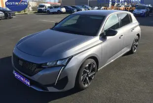 Vue 3/4 avant droit d'une Peugeot 308 gris Artense métal 2025 avec calandre noire et jantes bi-ton.