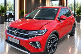 Volkswagen T-Cross rouge métal vue 3/4 avant avec jantes alliage noires et détails R-Line en intérieur showroom.