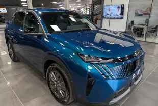 Vue 3/4 avant droite du Peugeot 3008 Hybrid 145 ch bleu Obsession, avec calandre distinctive et phares LED fins.