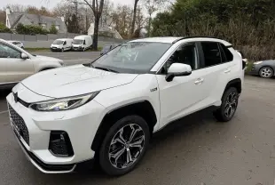 Suzuki Across hybride rechargeable blanc en vue 3/4 avant droit, avec jantes noires et détails noirs contrastants.