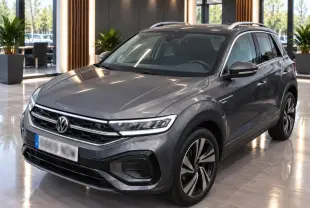 Volkswagen T-Roc gris platinium en 3/4 avant droit avec jantes alliage et toit noir en showroom.