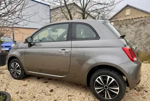 Vue côté gauche en 3/4 arrière d'une Fiat 500 gris foncé avec jantes alliage et poignées chromées.