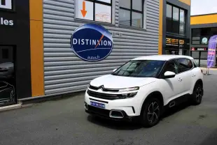 Citroën C5 Aircross blanc en 3/4 avant droit, avec jantes noires et toit contrasté noir, stationné devant un mur métallique.