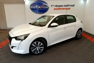 Peugeot 208 PureTech 75 blanc vue 3/4 avant droit en intérieur avec jantes alliage et phares LED distinctifs.