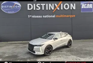 Vue 3/4 avant droite d'une DS4 beige 2024 avec calandre noire et jantes noires devant un mur gris.