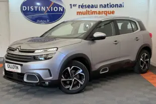 Citroën C5 Aircross gris clair en 3/4 avant droit, avec jantes noires et détails noirs sur les bas de caisse.