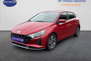 Vue 3/4 avant d'une Hyundai i20 1.0 TGDI rouge dragon métal avec jantes alliage et calandre noire distinctive.