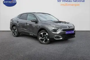 Citroën C4 X gris Platinium en 3/4 avant droit, avec signature lumineuse distinctive et jantes bicolores.