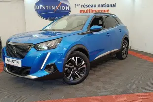 Peugeot 2008 bleu en 3/4 avant droit, avec calandre noire et jantes alliage bicolores visibles en intérieur showroom.