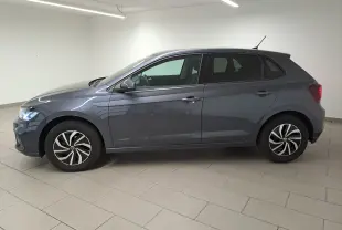 Volkswagen Polo gris cendre vue de profil côté gauche dans un intérieur lumineux avec jantes distinctives.