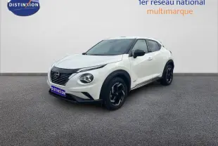 Vue 3/4 avant droit du Nissan Juke blanc 2024 avec jantes aluminium noires et calandre noire distinctive.