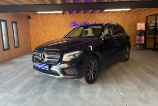 Mercedes GLC 220D Fascination noir en 3/4 avant droit, intérieur cuir beige visible, dans un garage avec murs en bois.