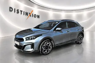 KIA Xceed gris en vue 3/4 avant droit, avec jantes alu distinctives et calandre chromée dans un showroom lumineux.