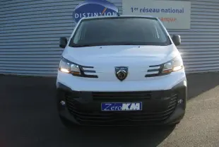 Vue frontale d'un Peugeot Expert Fourgon blanc 2025 avec phares allumés et logo lion visible sur la calandre.