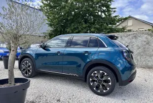 Vue latérale droite d'une FIAT 600 1.2 Hybrid bleu clair avec jantes stylisées et vitres surteintées.