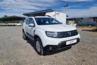 Dacia Duster blanc en 3/4 avant droit, SUV 4x4 avec calandre noire et protections noires sur les bas de caisse.