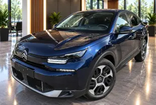 Citroën C4 2025 new dark blue vue 3/4 avant droit, avec signature lumineuse LED et jantes distinctives.
