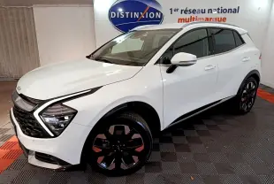 KIA SPORTAGE blanc en vue 3/4 avant droit, avec phares LED en forme de flèche et jantes noires distinctives.