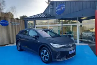 Volkswagen ID.4 148ch Pure 52 kWh Life Plus noir Ebène, vue 3/4 avant droit sur parking bleu devant concession.