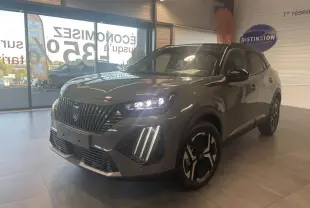 Peugeot 2008 gris métallisé en 3/4 avant droit, avec calandre noire et feux LED 3 griffes allumés en showroom.