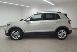 Volkswagen T-Cross Gris Ascot vue de profil côté gauche en intérieur, avec jantes alliage et toit noir contrasté.