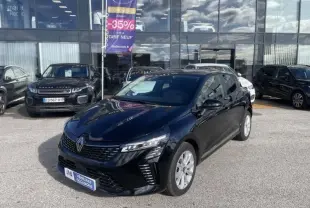 Renault Clio V 1.5 DCI 100 Evolution noire vue en 3/4 avant droit sur parking devant vitrine de concession.