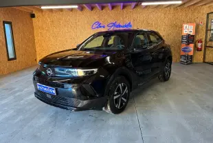 Opel Mokka 1.2 Turbo 145 Edition noir, vue 3/4 avant droit en intérieur avec éclairage naturel et néon bleu.