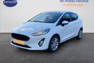 Ford Fiesta blanche vue en 3/4 avant droit, avec jantes classiques et vitres surteintées.